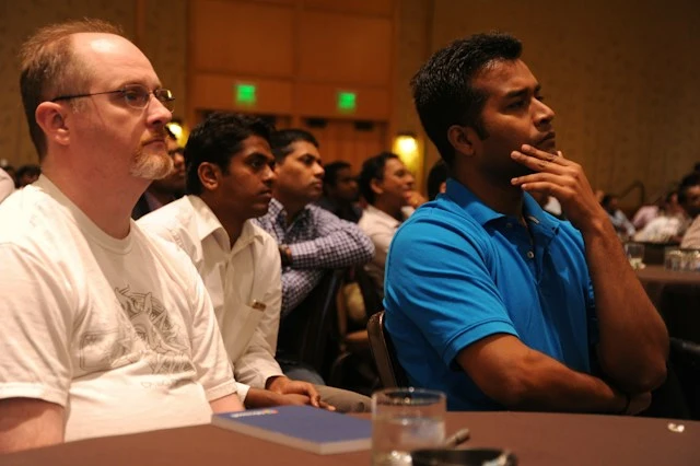 Attendees listening intently during a presentation at a corporate seminar.